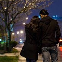 Photo d'un couple amoureux qui marche dans le rue la nuit